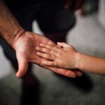 selective focus photography of child s hand
