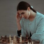 pensive ethnic woman thinking on chess move